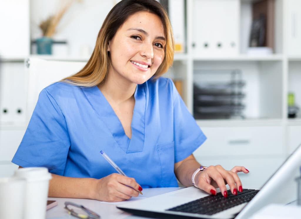 Doctor assistant working in medical office using laptop computer