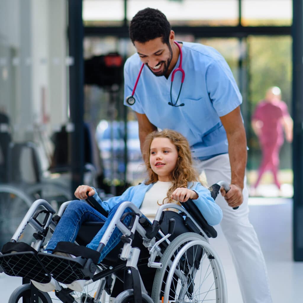 Nurse having fun with little girl on wheelchair